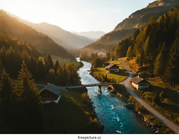 Sunlit River Flowing Through Lush Mountain Valley with Cottages