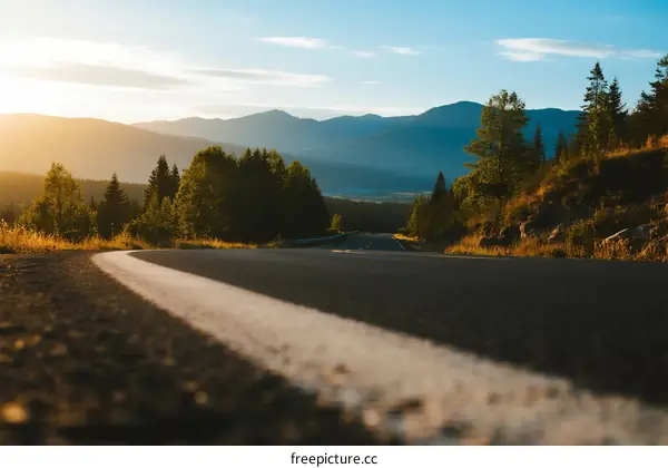 Scenic road at sunset with mountains in the background