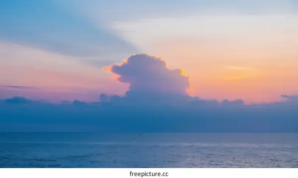 Vibrant sunset clouds over calm ocean waters at dusk