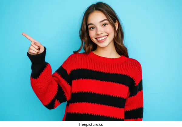 Smiling Young Woman Pointing with a Red and Black Striped Sweater