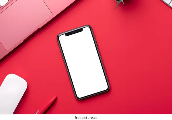 Top View Flat Lay Mockup of Red Desk with Smartphone, Laptop, Pen, and Mouse