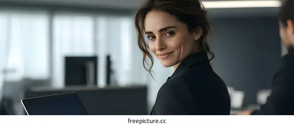 Smiling Woman in Office Looking Over Shoulder