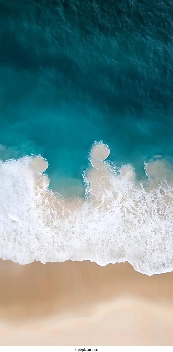 Aerial View of Ocean Waves Crashing on Sandy Beach