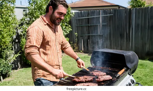 Man Grilling Steaks On Backyard Grill
