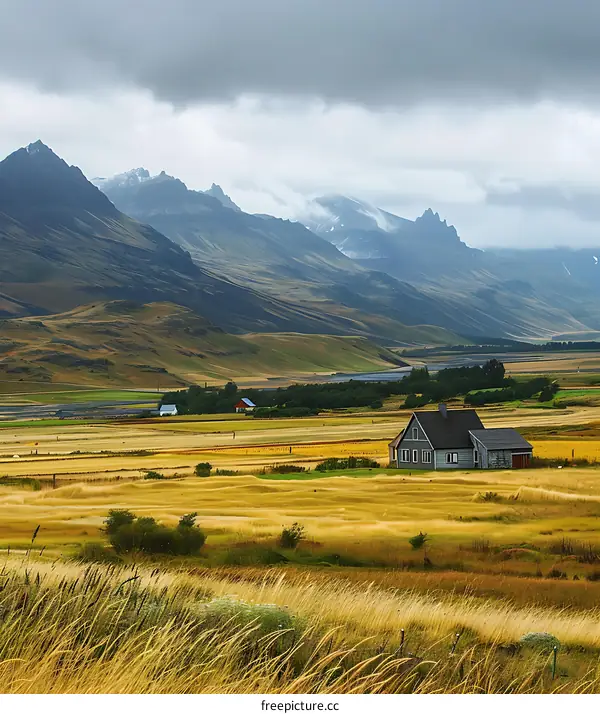 Scenic View of House in Valley with Mountain Range in Background