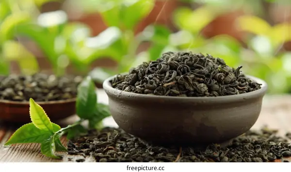 Green tea leaves in a bowl with green tea leaves in the background