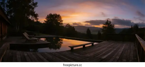 Stunning sunset view with a swimming pool on a wooden deck