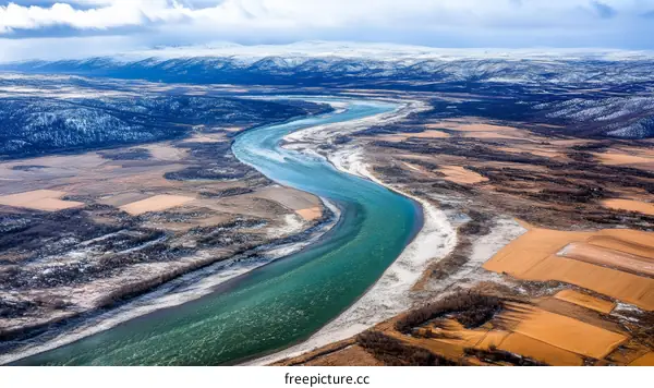 Aerial View of a Winding River Through a Snowy Landscape