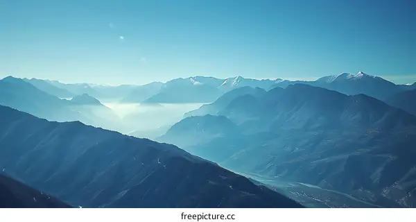 Mountain Range with Fog and Blue Sky