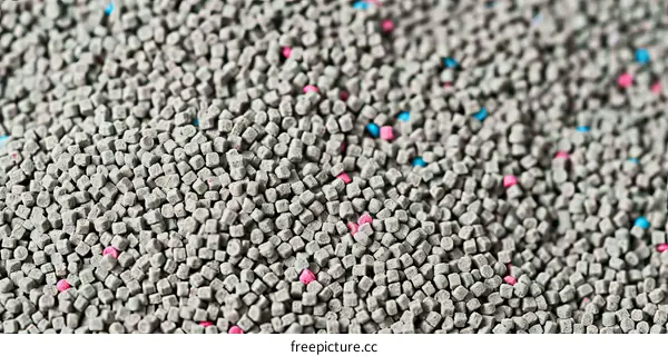 Close-up of gray cat litter with blue and pink crystals