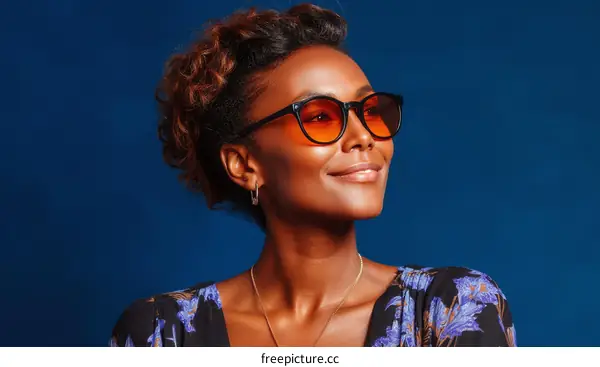 Stylish African Woman Wearing Sunglasses in Front of a Blue Background