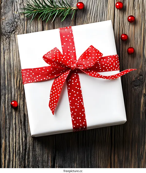 Christmas Gift Box with Red Ribbon and Bow on Wooden Background