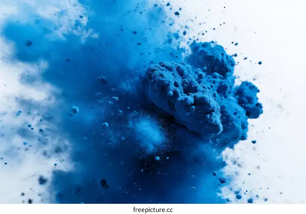 Vibrant Blue Powder Explosion in Mid-Air with Particles Flying