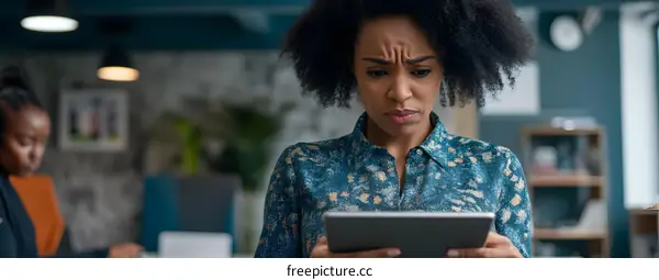 Serious African American Woman Looking At Tablet