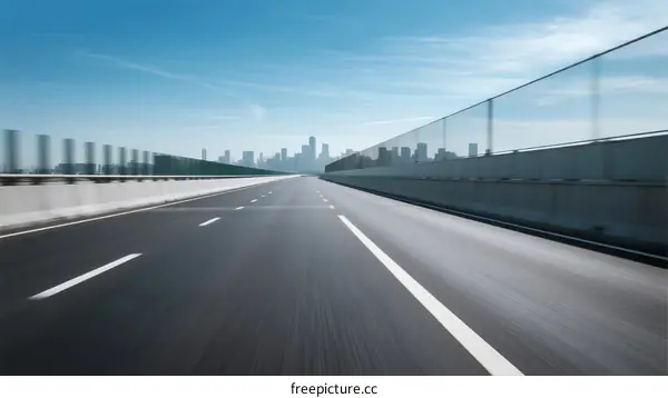 Smooth highway leading towards a modern city skyline under a clear blue sky