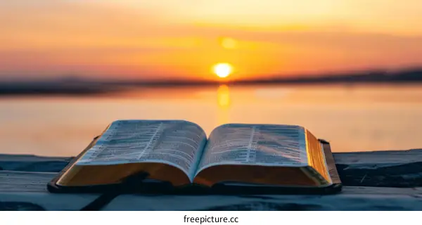 Open Bible on a Wooden Dock at Sunset