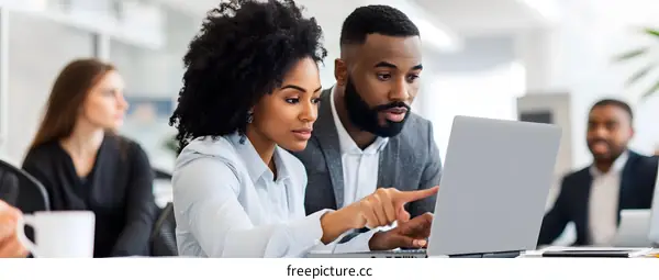Two Business Professionals Working Together on a Laptop in an Office