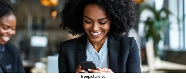 Happy African American Businesswoman Uses Phone in Cafe