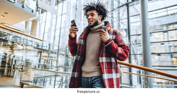 African American Man Using Smartphone in Modern Building