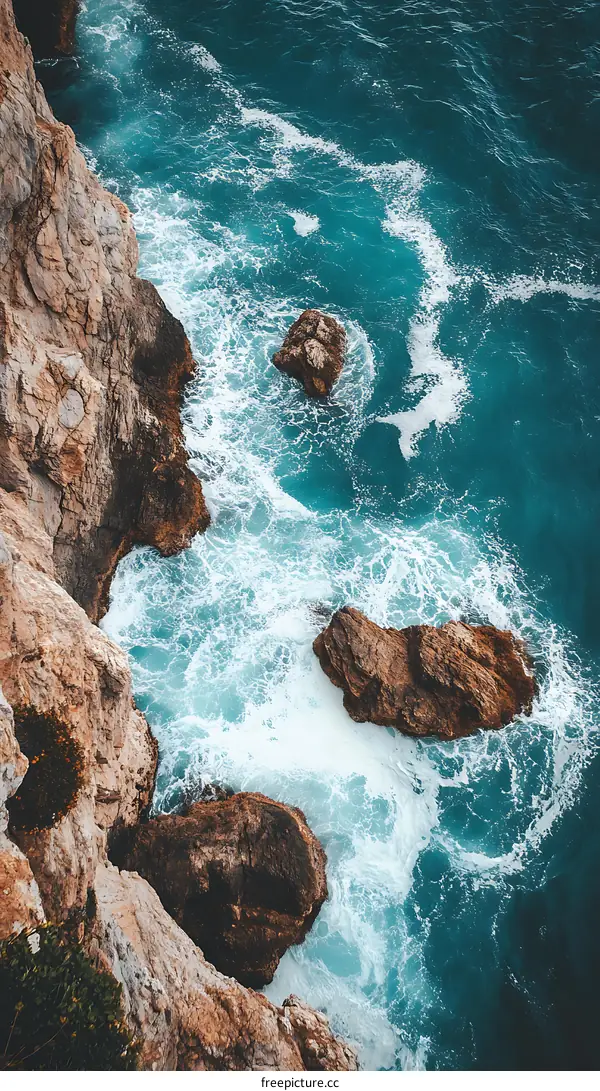 Aerial View of Ocean Waves Crashing Against Rocks