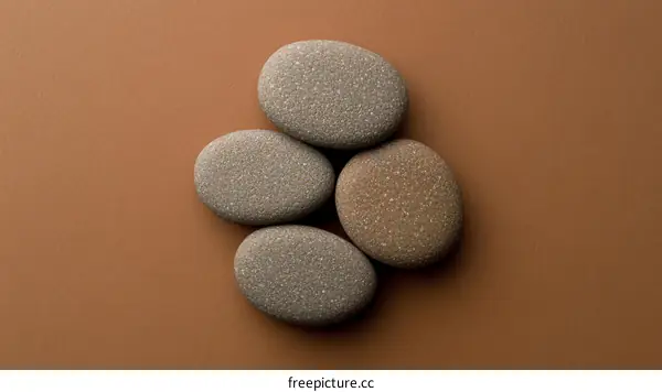 Five Smooth Stones on a Tan Background