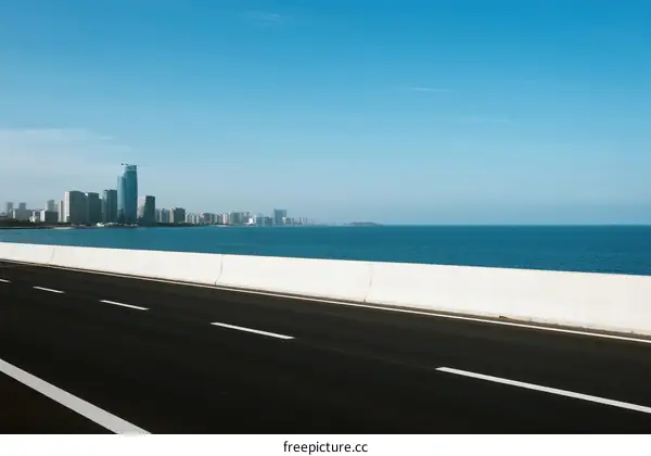 Smooth highway with city skyline and sea view in the distance