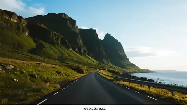 Scenic road winding through green mountains and near the sea