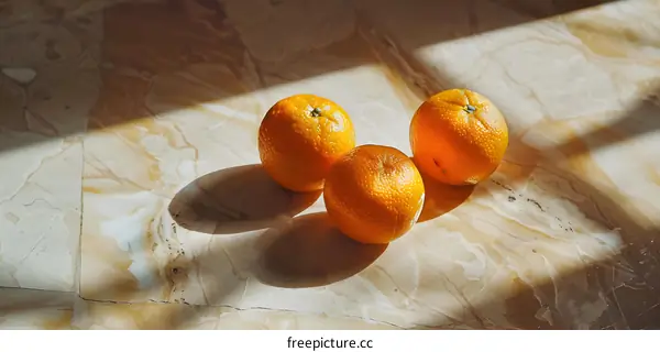 Three Oranges on a Marble Surface with Natural Light