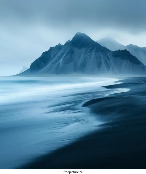 Black sand beach in Iceland with large mountain in the background