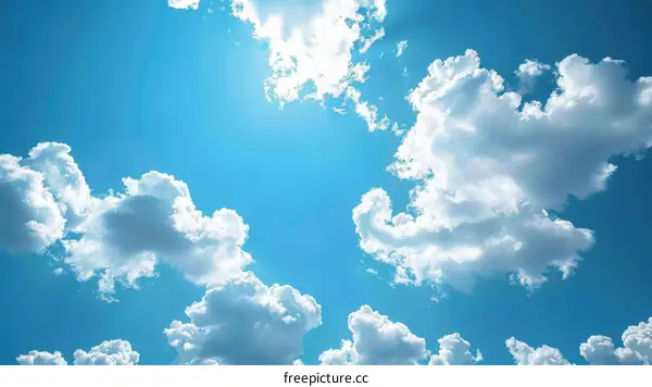 Sunlight Breaking Through Fluffy Clouds in a Blue Sky
