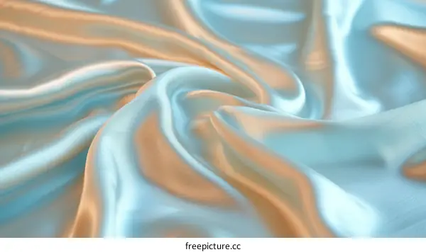 Close-up shot of a soft, wavy, blue and gold silk fabric.