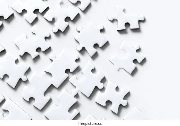 White Jigsaw Puzzle Pieces Scattered on a White Surface