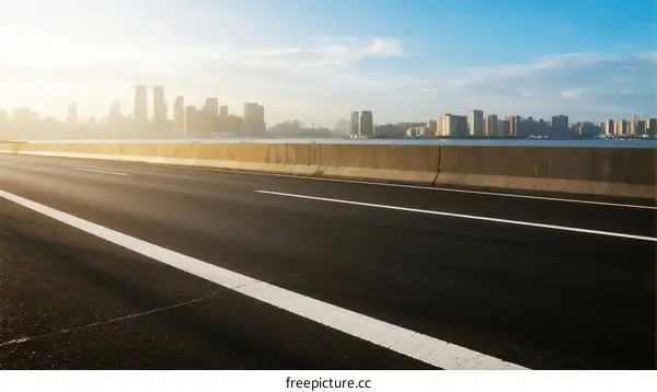 Smooth highway leading to a modern city skyline under clear sky