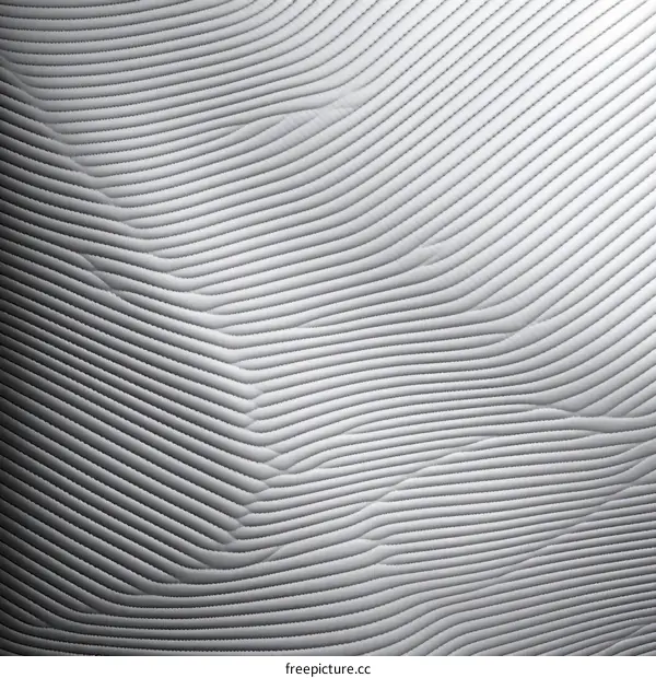 Wavy white fabric with quilted geometric pattern