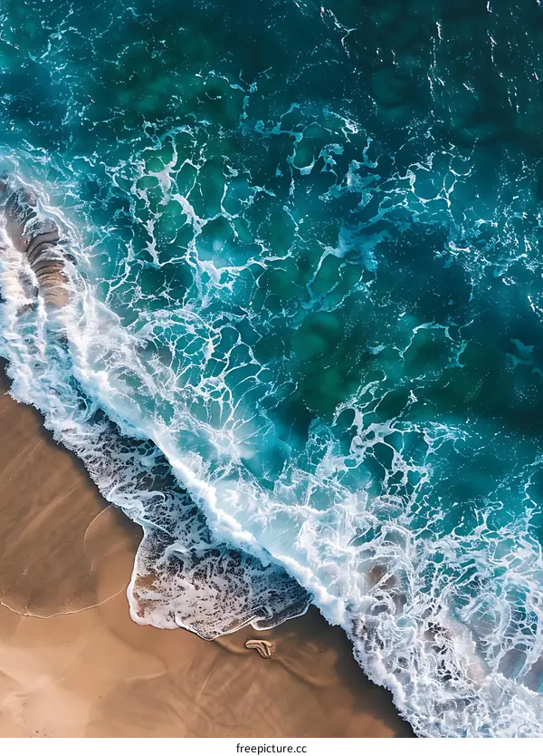Aerial View of Ocean Waves Crashing on Sandy Beach