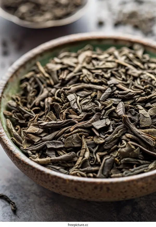 Green tea leaves in a ceramic bowl