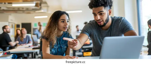Two Colleagues Working Together on Laptop in Modern Office