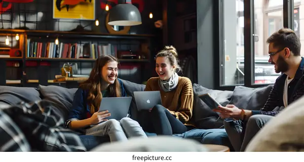 Three Friends Relaxing on a Couch with Laptops and Tablets