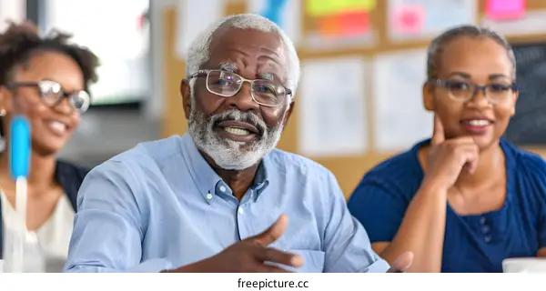 Smiling Senior Man Leading a Conversation with Two Attentive People