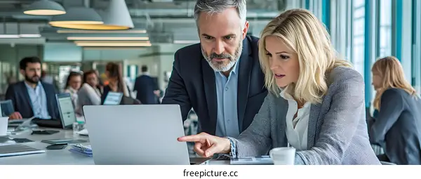 Two Business Professionals Working Together on a Laptop in an Office