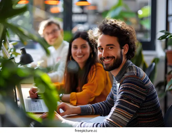 portrait of a smiling man and woman sitting at a table and looking at the camera