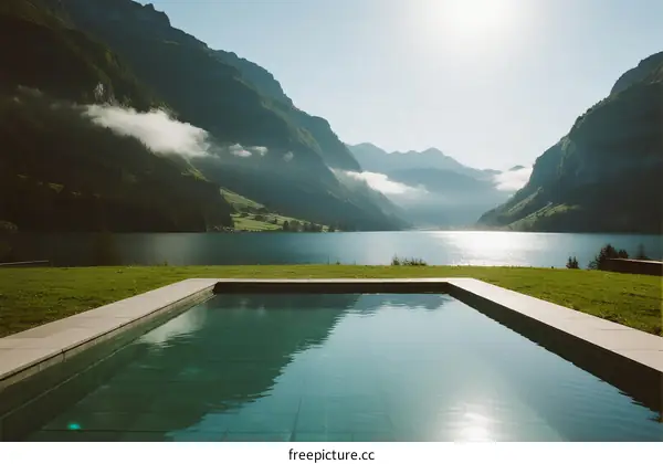 Mountain lake with infinity pool under bright sunlight