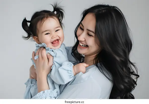 Happy Mother and Baby Daughter Laugh Together