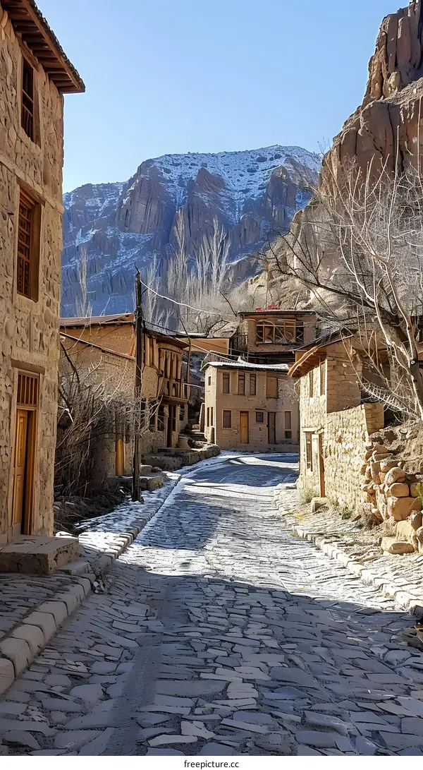 An ancient stone village with snow-capped mountains in the background