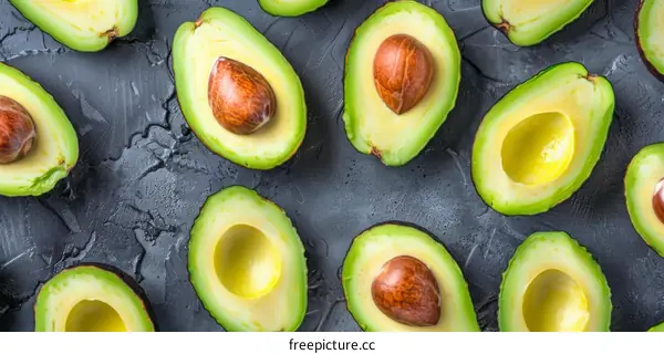 Various avocado halves on a dark background