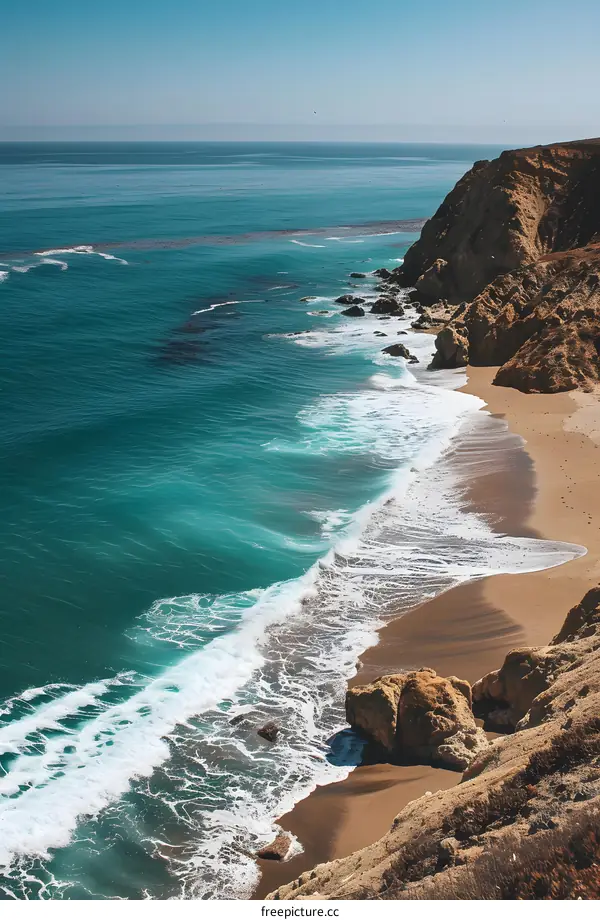 Aerial View of the Pacific Ocean Coastline with Waves Crashing on the Sandy Beach