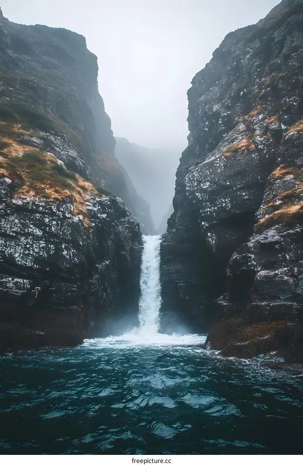 Waterfall Flowing Into Sea Through Two Cliff Faces