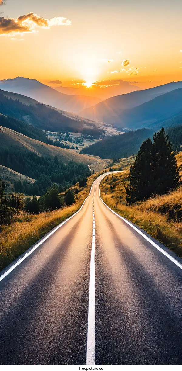 Empty Road Through Mountain Valley at Sunset