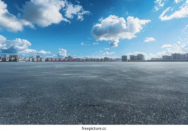 Empty Parking Lot with City Skyline and Blue Sky
