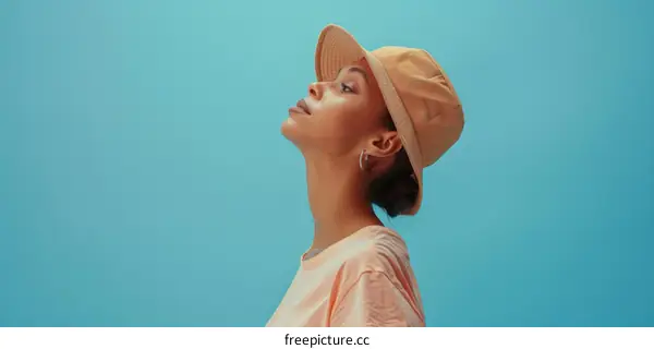 Close-up portrait of a young woman wearing a hat looking away from the camera
